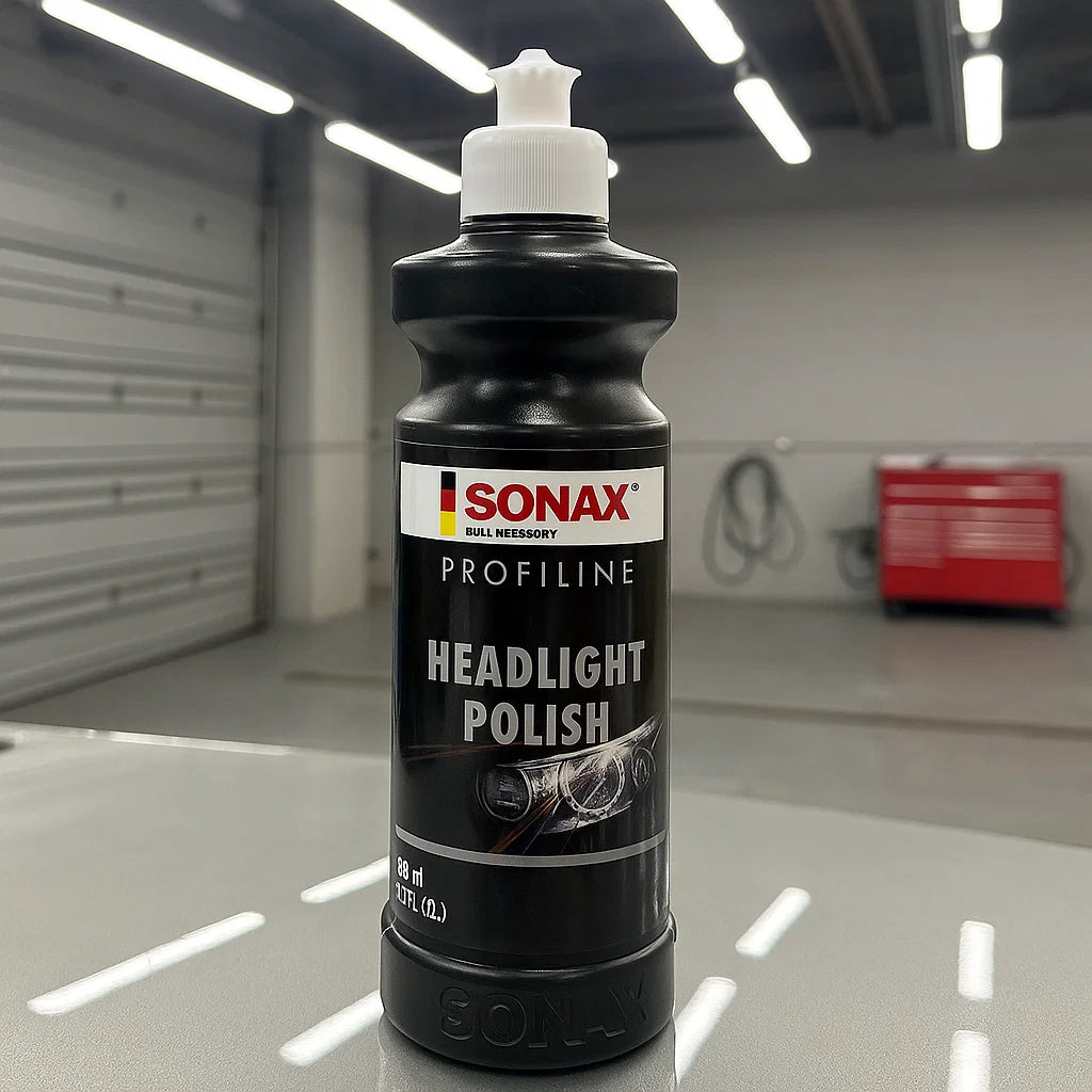 Flasche Sonax Profiline Headlight Polish in einer Werkstatt auf einem Fahrzeug platziert.