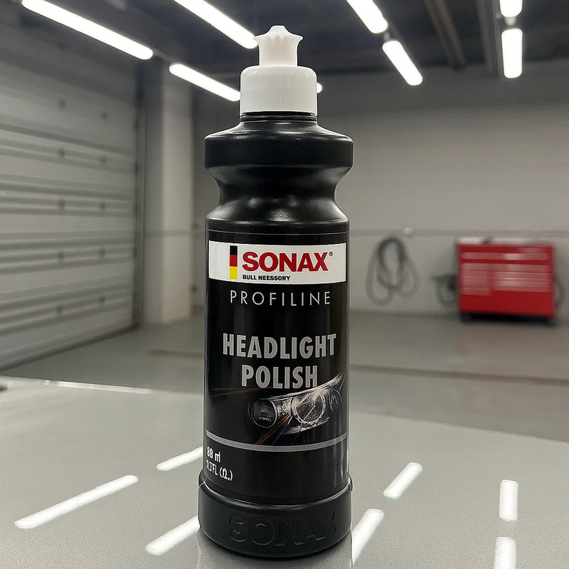 Flasche Sonax Profiline Headlight Polish in einer Werkstatt auf einem Fahrzeug platziert.